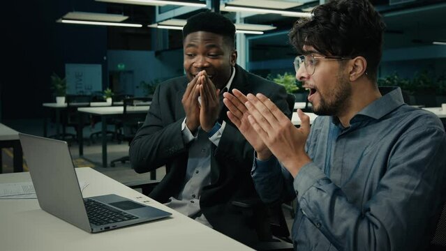 Happy colleagues businessmen male winners work with laptop win online bet lottery business achievement fortune two excited people men friends celebrate internet victory effective corporate teamwork