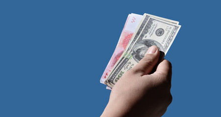 Isolated hand holding banknotes of Yuan and US Dollar with clipping paths.