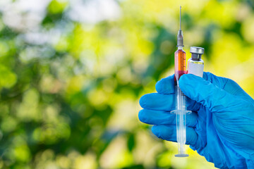 female doctor hand wears medical glove holding syringe and vial bottle, flu medicine treatment vaccination concept.