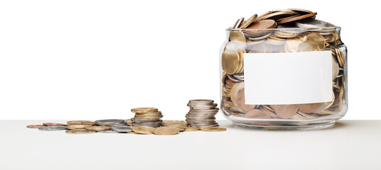 Coins in glass jar on the desk for money saving financial concept