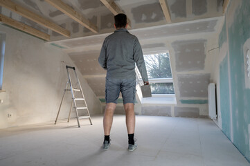 Man plastering drywall in a private house.