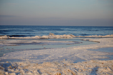 Winter view on the icy sea coast and beautiful calm sky, selective focus