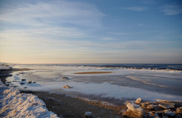 Winter view on the icy sea coast and beautiful calm sky, selective focus