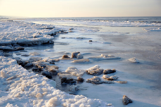 Winter view on the icy sea coast and beautiful calm sky, selective focus