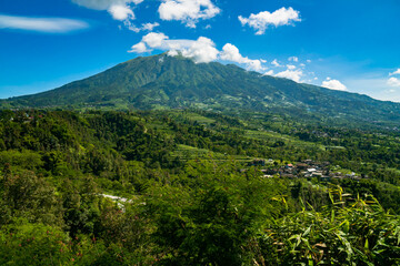 The beauty of Mount Merbabu seen from Ketep Pass, a mountain covered with green hills and blue sky and a few clouds that spoil the eyes of visitors