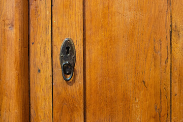 Lock and handle in the door of an old wooden cabinet Keyhole close up