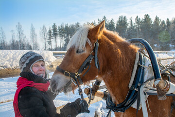 Woman with horse and sleigh in winter