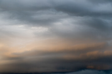 Dark cloud before raining storm and have the orange cloud that reflect light from sunset as background