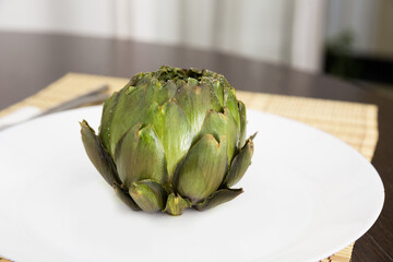 Obraz premium cooked whole artichoke on a white plate