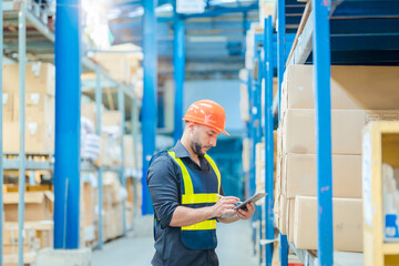 Warehouse workers in helmets checking goods and supplies on shelves with goods background in...