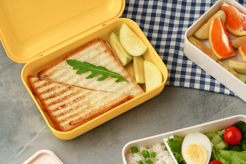 Containers with healthy food on gray background top view.