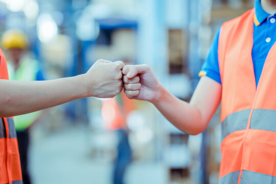 actory workers stacking hands together in warehouse or storehouse . Logistics , supply chain and warehouse business concept ..