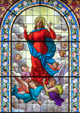 DOMODOSSOLA, ITALY - JULY 19, 2022: The Assumption of Virgin Mary on the stained glass in church Chiesa dei Santi Gervasio e Protasio by Luigi Fontana from 19. cent.