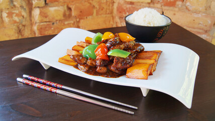 Asian combination plate with fried pork and vegetables and served with rice or noddles.    