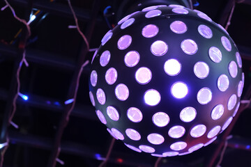 close up one purple disco ball light at night.