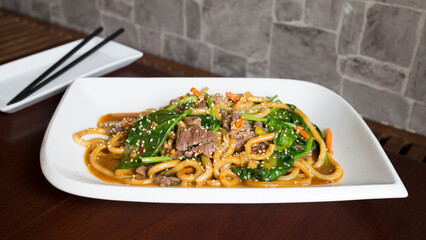 Asian combo plate with beef, noodles, rice and vegetables.