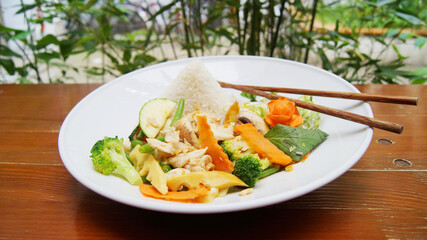 Asian combo plate with chicken and vegetables served with rice.