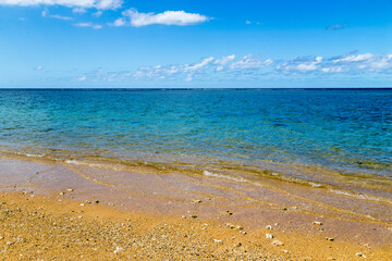 Bord de lagon tropical émeraude et turquoise avec plage de sable et ciel pour arrière-plan