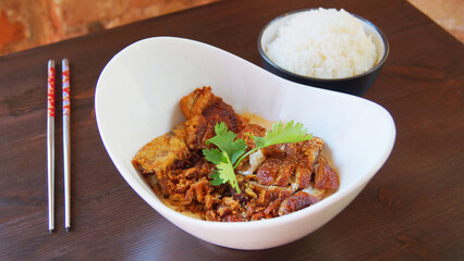 Dish with crispy duck in a restaurant in China. Asian combo plate with and vegetables and rice.