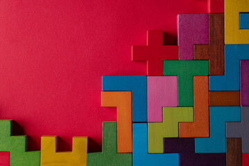 Top view on colorful wooden blocks folding on red background.