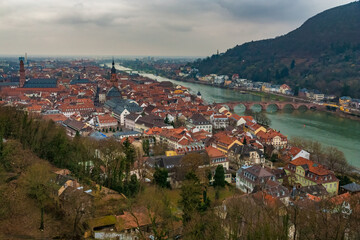 Fototapeta na wymiar Lovely view of Heidelberg's old town in winter with the two churches Jesuitenkirche and Heiliggeistkirche and the bridge Alte Brücke over the Neckar river with the hill Heiligenberg in the background.