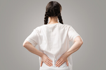 Back pain. The woman holds her hands to the small of her back. Arthritis chondrosis. The concept of...