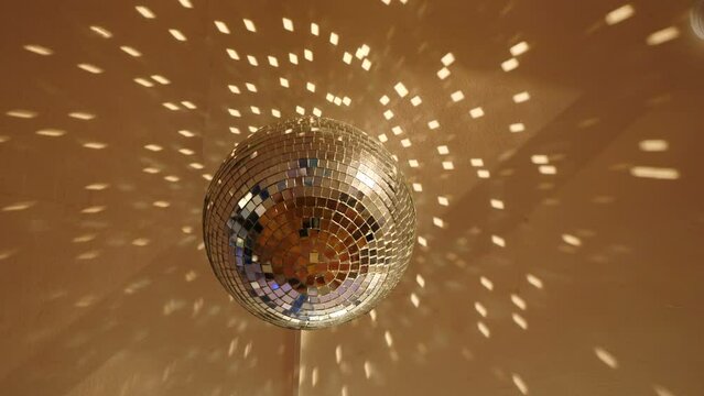 Bright large retro silver disco ball rotating close up. Rotating disco mirror ball. Sparkling disco balls spinning with flashing lights during music band performance or dancing party. 4 k video