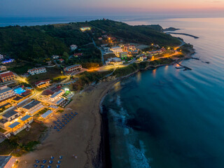 Aerial drone view of Agios Stefanos beach, a small tourist resort on the north east coast of Corfu in Greece by night