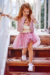 pretty little baby girl going down the stairs. Girl's fashion. Tutu skirt