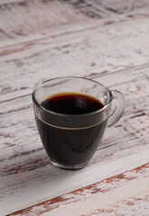 Coffee inside clear glass on the wooden Table. Selective focus. Vertical Banner