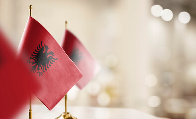 Small flags of the Albania on an abstract blurry background