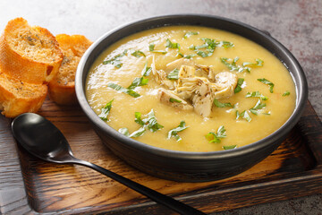 Vegetable cream soup of artichokes, potatoes, leeks and garlic served with toasted bread close-up...