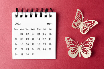 The May 2023 desk calendar for the organizer to plan and reminder with paer butterfly on red background.