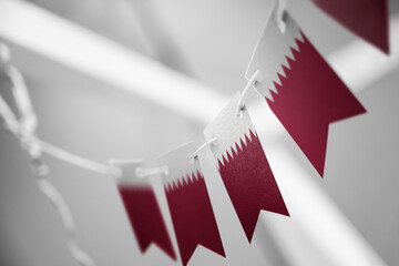 A garland of Qatar national flags on an abstract blurred background