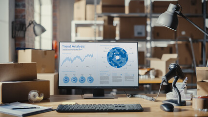 Desktop Computer Monitor Standing on a Table with a Trend Analysis Charts Display. Small Business Storage Room in the Background. Desk with Cardboard Boxes. Statistics, Graphs, and Sales Data