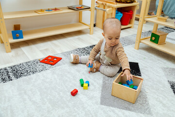 Toddler playing with montessori Imbucare shapes box