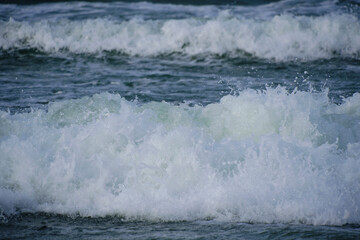 Surf wave with foam splashes on sea.