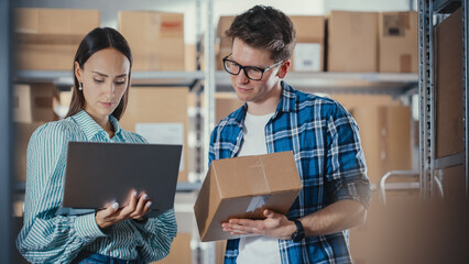 Young Male and Female Warehouse Inventory Managers Packing Orders for Clients, Using Laptop...