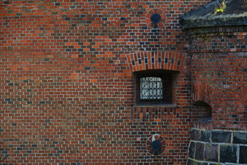 Wall old brick fortress with loopholes.