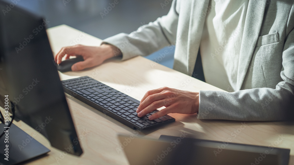 Poster Young Male Employee in Gray Casual Jacket Working on Computer in Office During Daytime Close Up on Hands of a Manager Typing Texts on a Keyboard, Writing Text and Using Mouse.