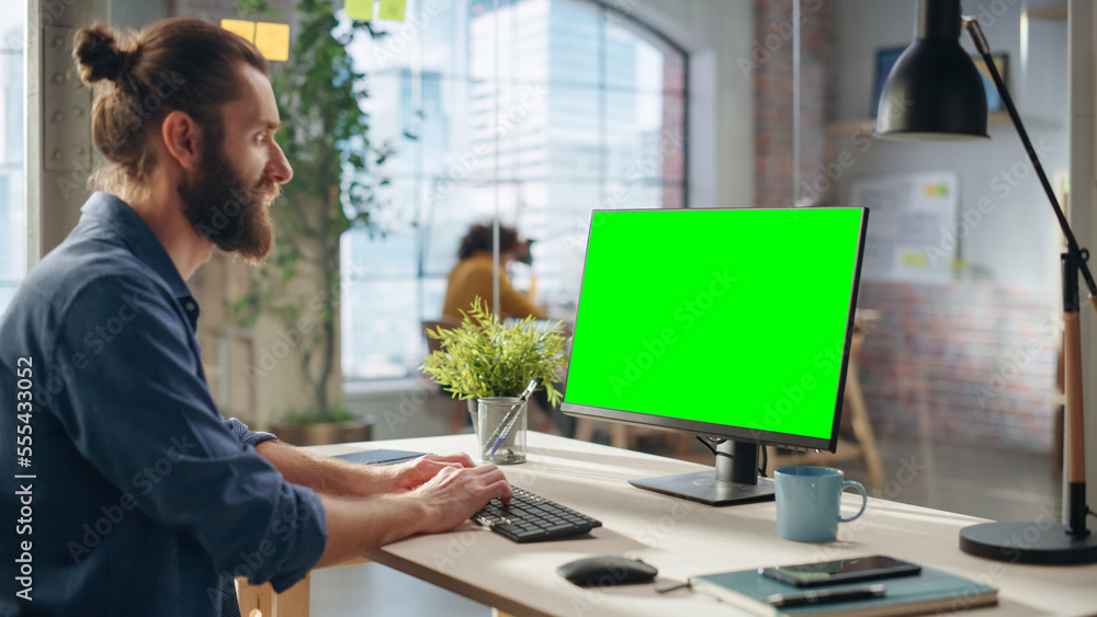 Poster creative project manager working on desktop computer with green screen mock up display. bohemian sty