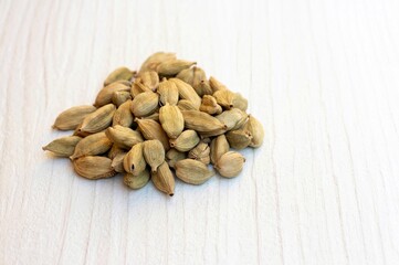 Dry Cardamom or Cardamon Isolated on White Wooden Background with Copy Space