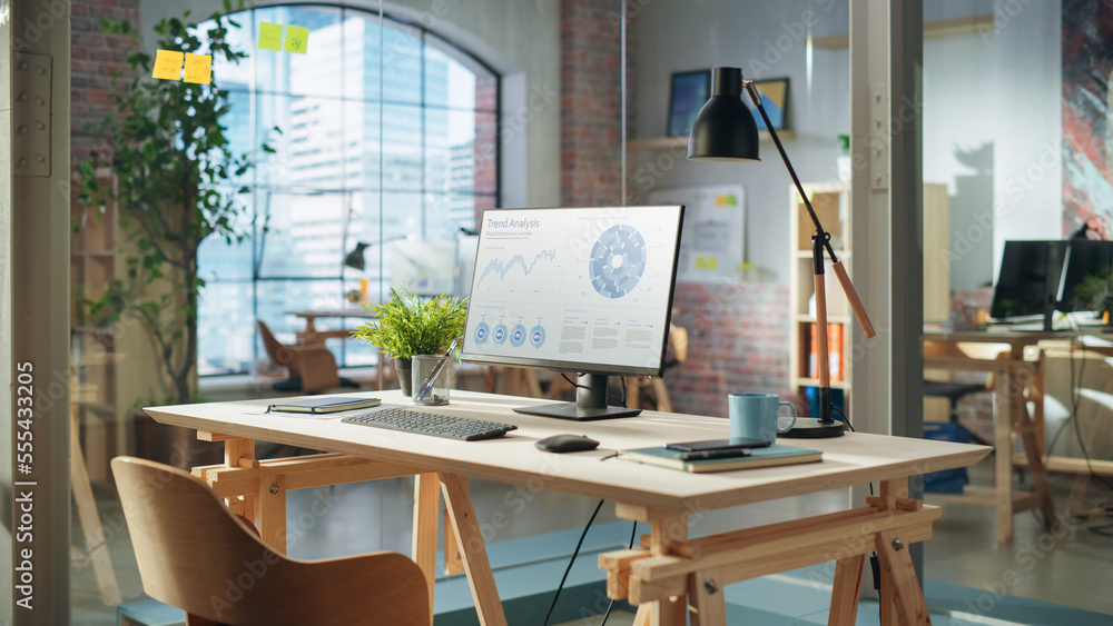 Aufkleber Establishing Shot: Desktop Computer Monitor with Trend Analysis Charts and Data Display Standing on a Desk in Modern Creative Office. Cozy Agency Space in Loft Building.