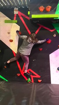 People bouldering on a climbing problem in a ninja warrior type experience