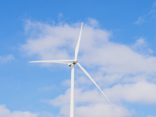Close-up of Wind electric generator. Wind generators stand in agricultural fields with Powerful wind turbine farms for pure energy production on the background.	