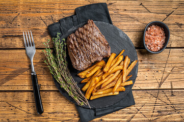 Venison dear steak with   sea salt and french fry, game meat. Wooden background. Top view