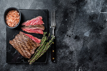Grilled Wild Venison steak with thyme and salt, game meat. Black background. Top view. Copy space