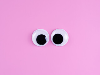 googly eyes funny cute Isolated on bright light pink background copy space logo