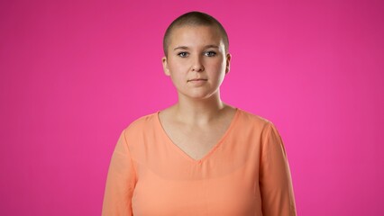 Smiling young gender fluid woman 20s years old posing isolated on pink background studio. People sincere emotions lifestyle concept. Looking at camera with charming smile