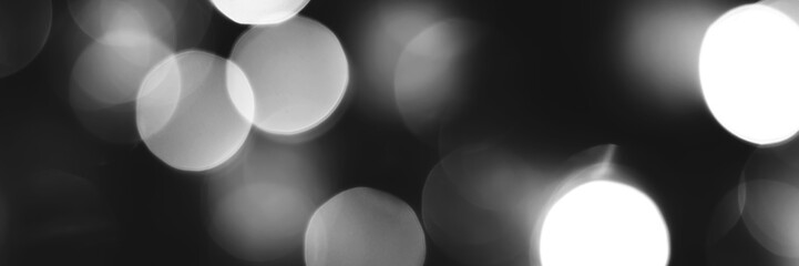 Blurred lights black and white background, banner texture. Abstract bokeh with soft light header. Wide screen wallpaper. Panoramic web banner with copy space for design